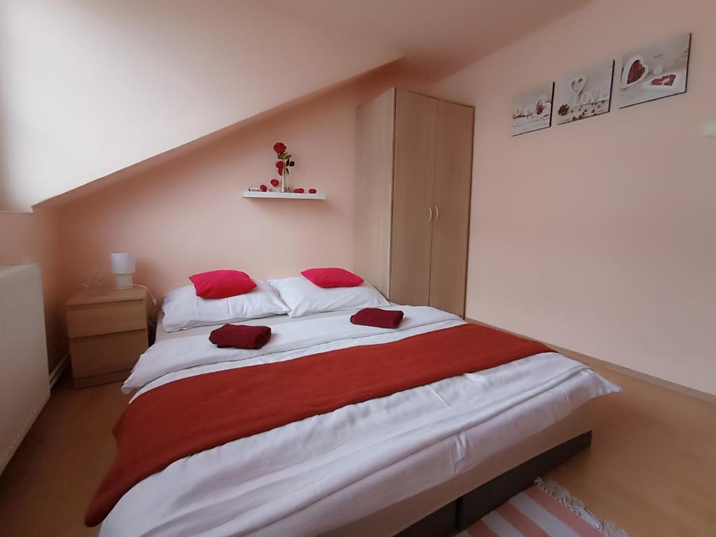 una camera da letto con un grande letto con cuscini rossi di Penzion Jáchymov Pod Lanovkou a Jáchymov