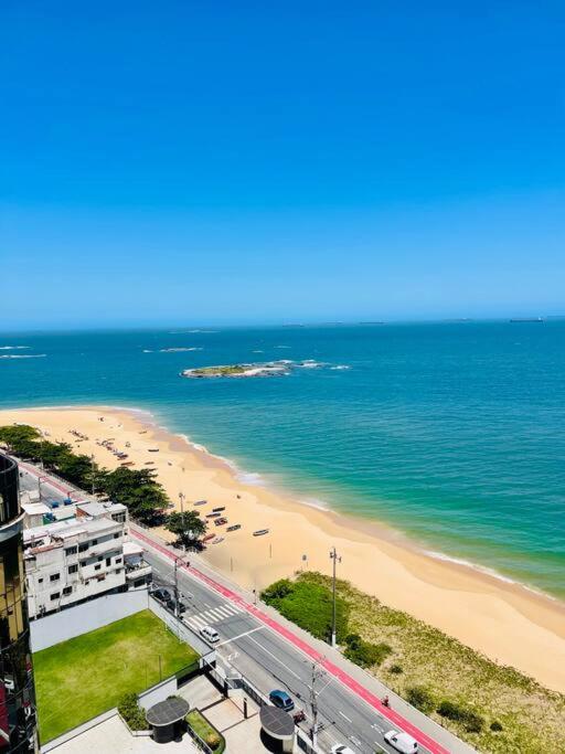 een uitzicht op een strand met een weg en de oceaan bij 2 Quartos Frente Mar em Itapuã in Vila Velha