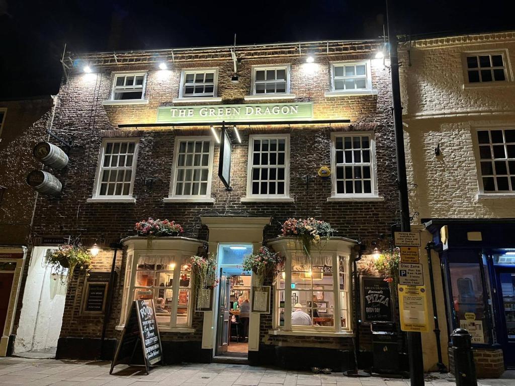 a brick building with a sign that reads the green dragon at The Green Dragon at Bedale in Bedale