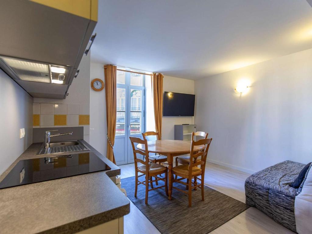 une cuisine et un salon avec une table et des chaises dans l'établissement Studio au cœur de Cauterets, 4 pers, 2 coins nuit, cuisine équipée, proche commodités et télécabine - FR-1-401-149, à Cauterets