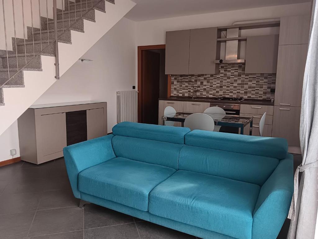 - un canapé bleu dans un salon avec une cuisine dans l'établissement Appartamento al Globo, à Busnago