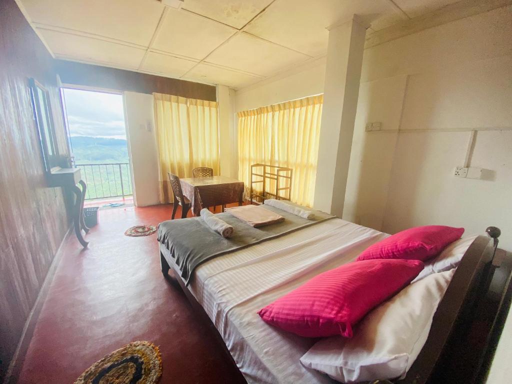 um quarto com uma cama com almofadas vermelhas em Rosenka haputhale em Haputale