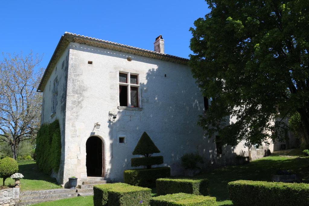 - un petit bâtiment blanc avec un arbre dans la cour dans l'établissement La Gilbertie, à Allemans