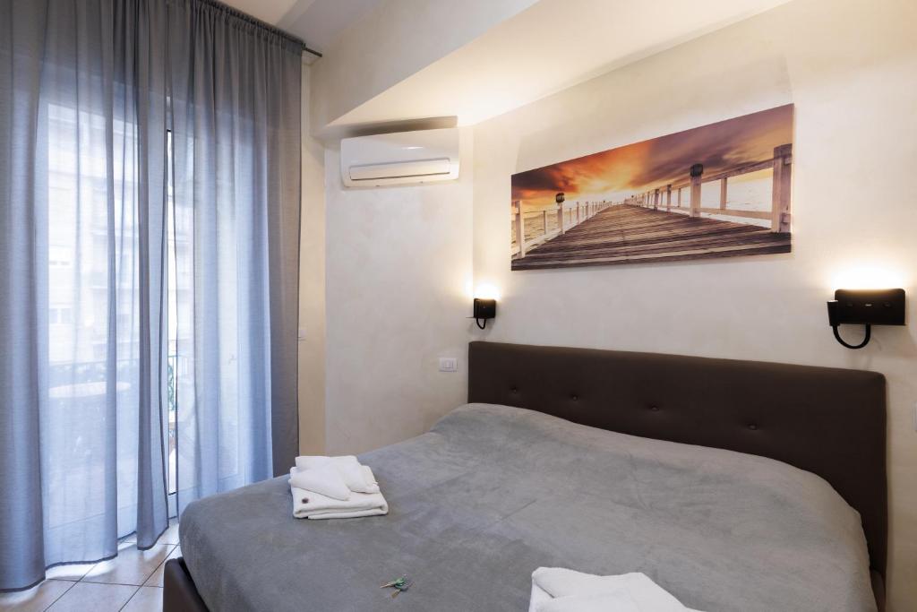 een slaapkamer met een bed en een schilderij aan de muur bij Roma Marine House in Lido di Ostia