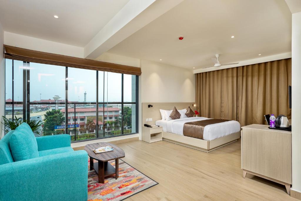 ein Hotelzimmer mit einem Bett und einem großen Fenster in der Unterkunft PRESIDENCY AIRPORT HOTEL in Kochi