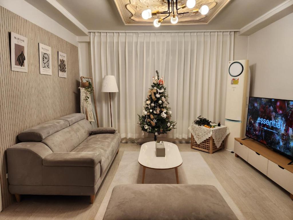 a living room with a couch and a christmas tree at The Shim Anam 3rooms late check in-out in Seoul