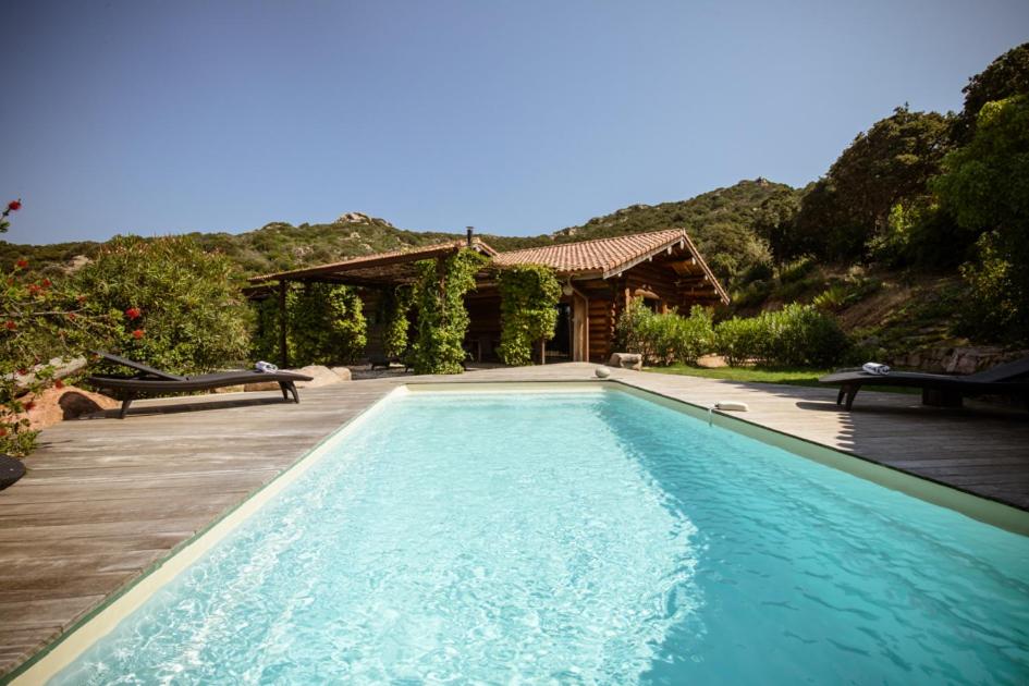 a swimming pool in front of a house at Casa Laricciu in Figari