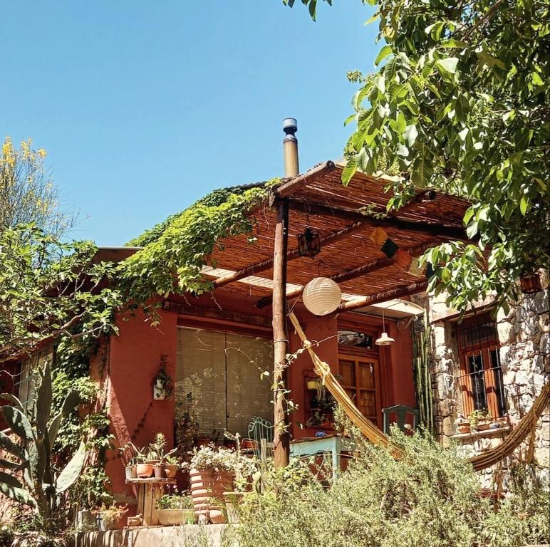 ein rotes Haus mit einem mit Efeu bedeckten Dach in der Unterkunft Casa.Colibri.LaCumbre in La Cumbre