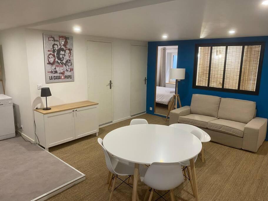 ein Wohnzimmer mit einem weißen Tisch und einem Sofa in der Unterkunft Coeur de Jaude 2 chambres Tout équipé 4 personnes in Clermont-Ferrand