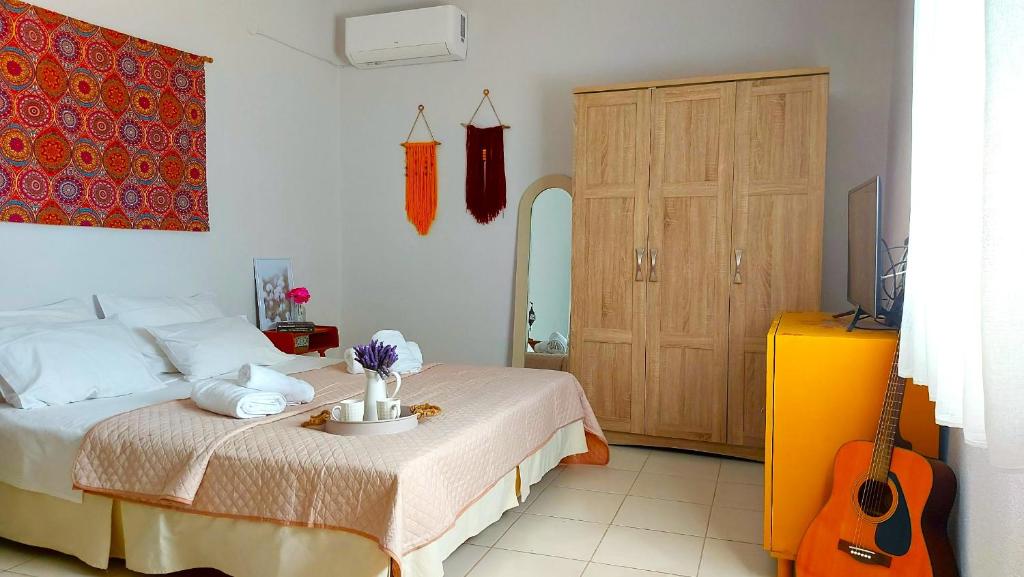 a bedroom with a bed and a guitar in it at Agritourism Cottage near Sitia (Henhouse) in Sitia