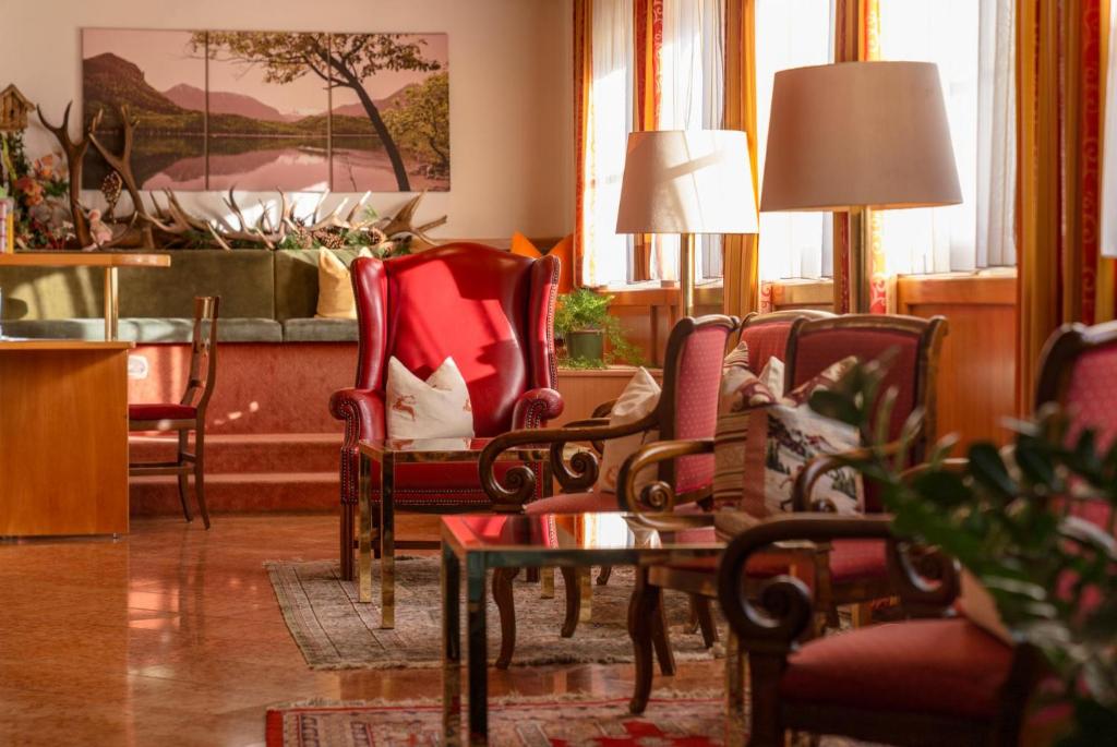 a living room with chairs and a table and a bed at Hotel Restaurant Lebzelter in Altenmarkt im Pongau