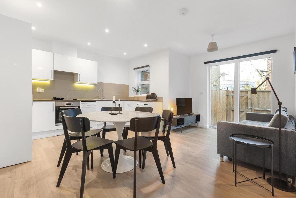 a kitchen and dining room with a table and chairs at Spacious Clapham Apartments in London