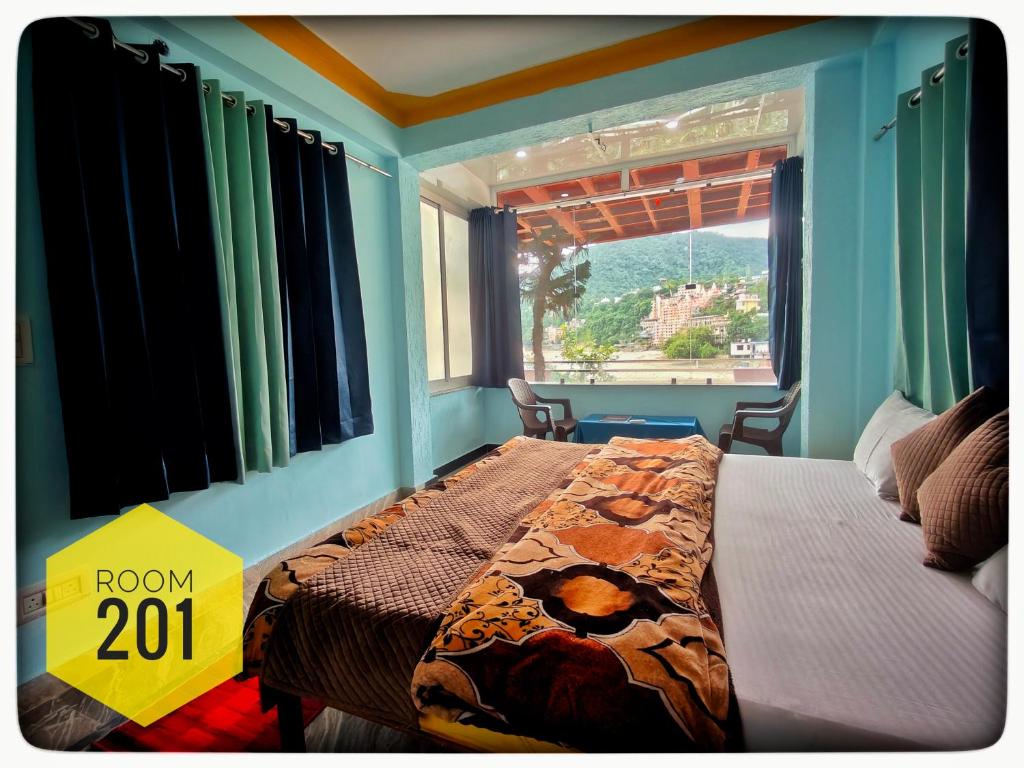 a bedroom with a bed with a sign that says room at Shri Ganga View Guest House in Rishīkesh