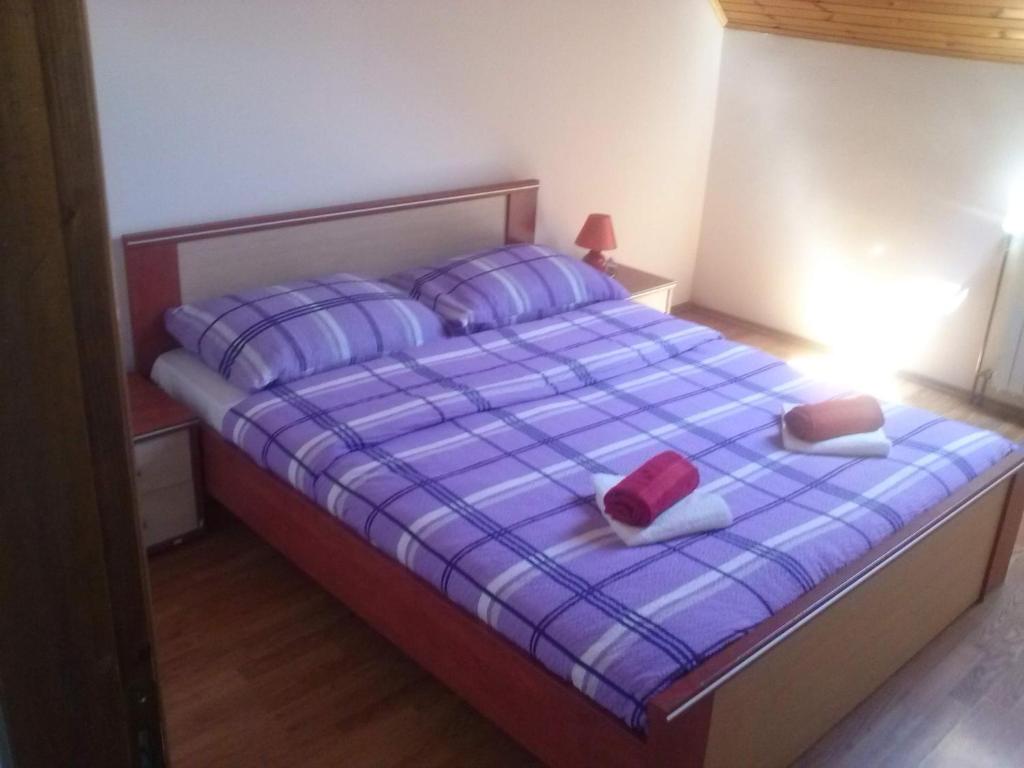 een slaapkamer met een bed met 2 hoeden en kussens bij Galeva apartman in Smoljanac