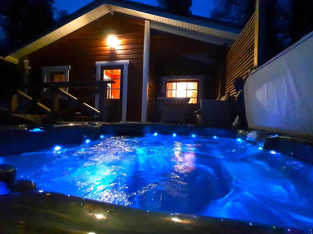 uma grande banheira de hidromassagem num quintal à noite em Villa Mäkivaski em Virrat