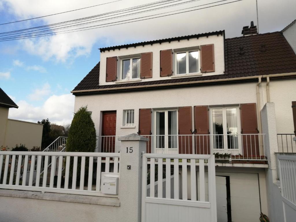 a white house with a white fence at PAVILLON PROCHE RER et DisneyLand in Gagny
