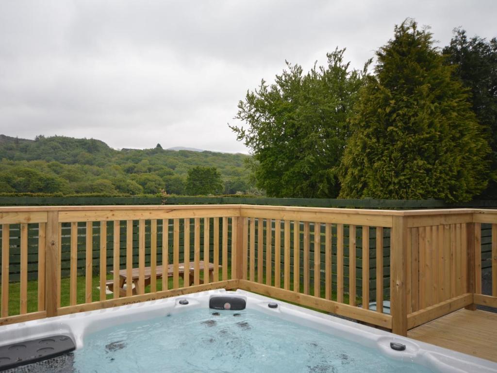 a hot tub on a deck with a fence at 2 Bed in Okehampton 74242 in Okehampton