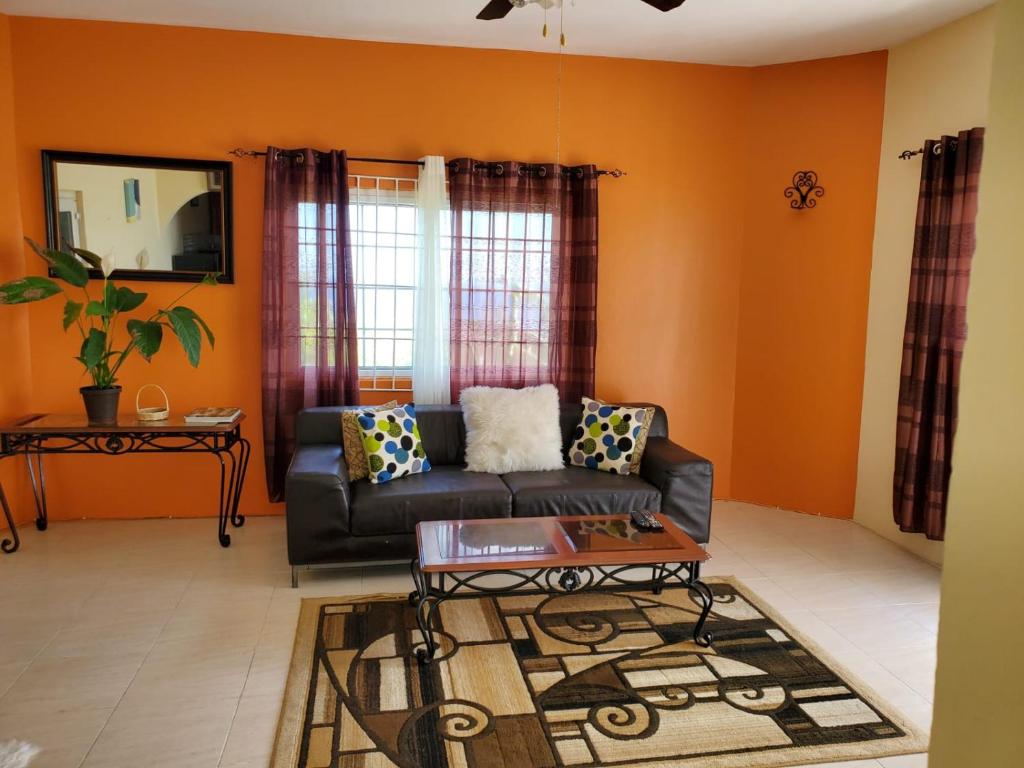 uma sala de estar com um sofá e uma mesa em Spring Valley Estate Ocean View Apartments em Saint Mary
