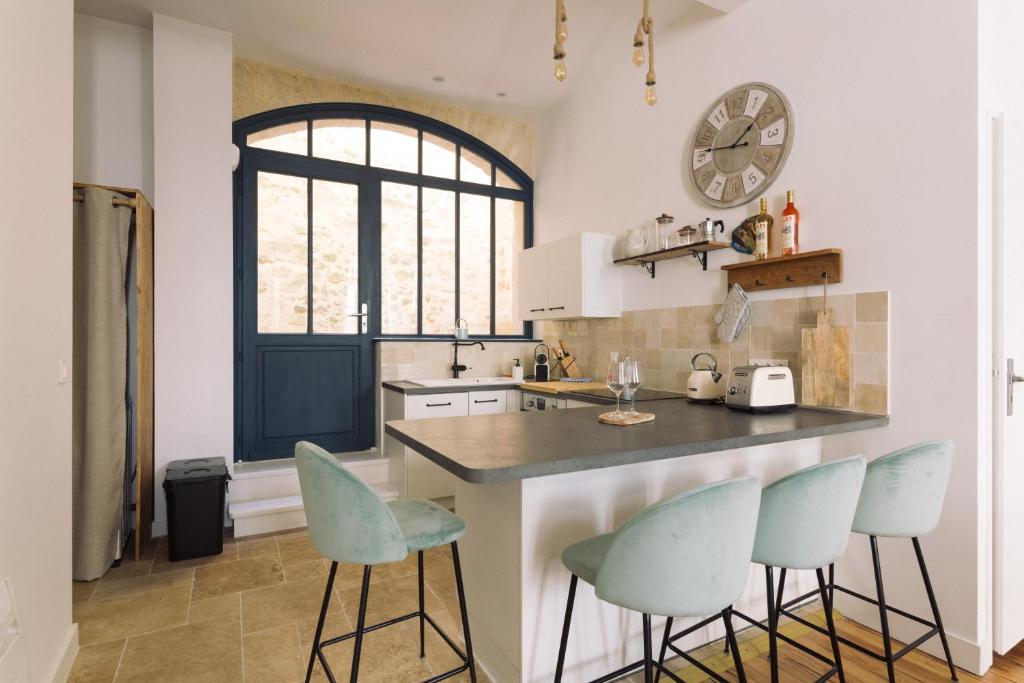 une cuisine avec un comptoir et trois tabourets dans l'établissement By Homy, à Bordeaux