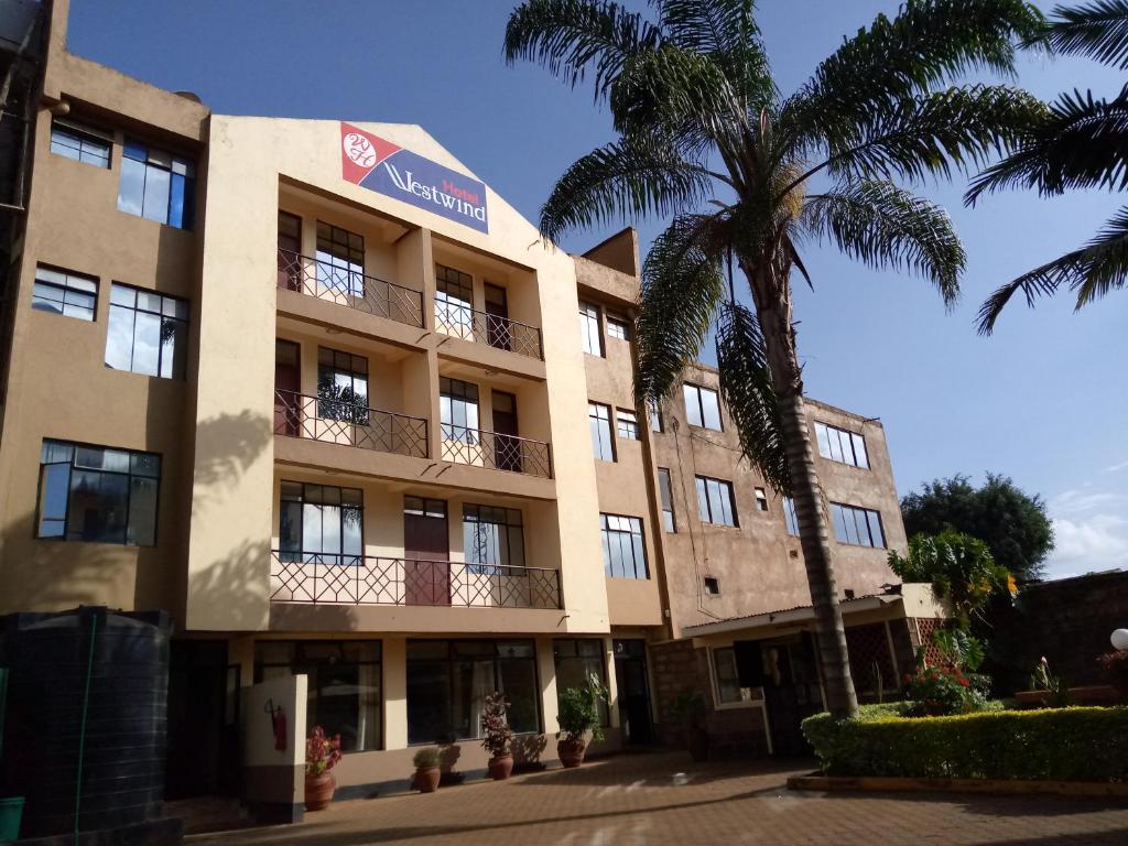 budynek z palmą przed nim w obiekcie Westwind Hotel Limited w mieście Meru