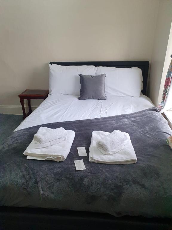 łóżko z dwoma ręcznikami na górze w obiekcie House In the heart of valleys w mieście Ebbw Vale