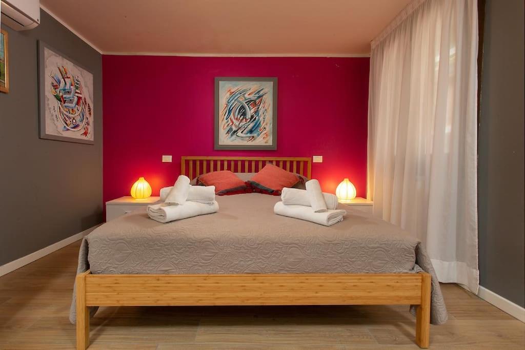 une chambre avec un grand lit aux murs rouges dans l'établissement Biennale Comfort House - modernità a Castello, à Venise