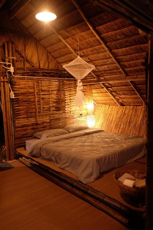 Cama grande en habitación con techo de madera en Royal mountain lake view, en Ratchaburi