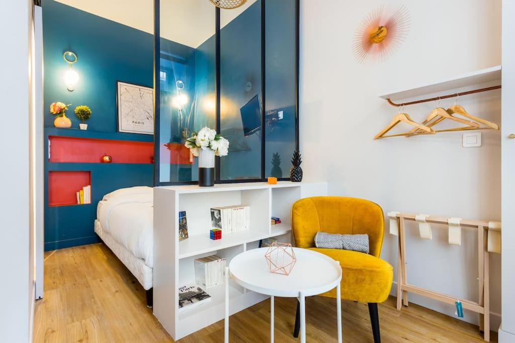 une chambre avec un lit, une table et une chaise dans l'établissement Cosy studio - Arc de Triomphe, à Paris