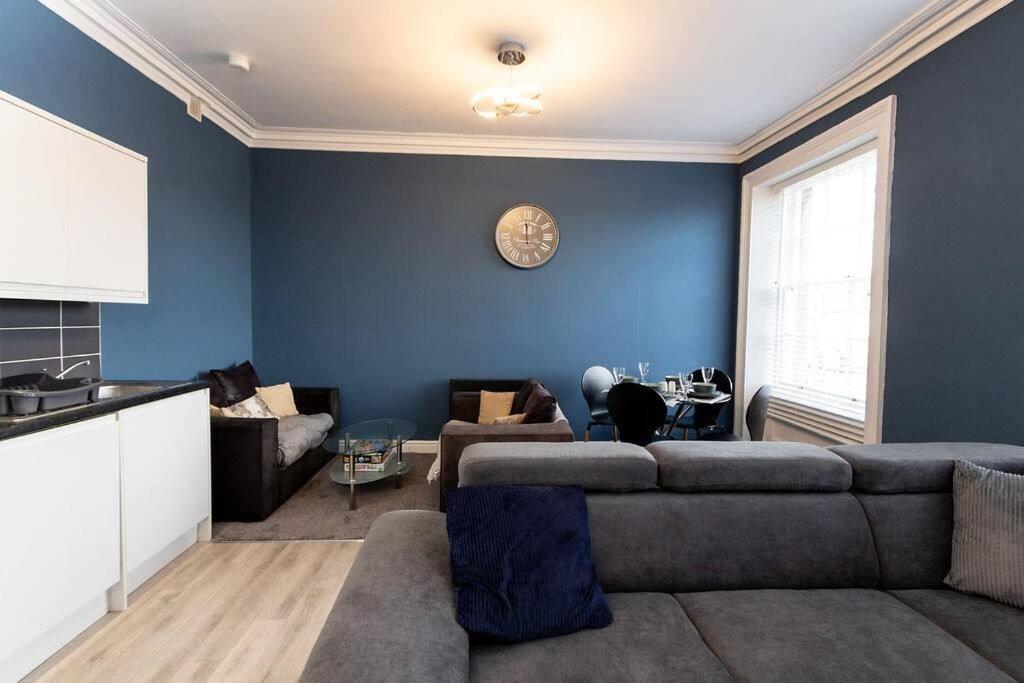 バーケンヘッドにあるLavish 2Bed Apartment in the Heart of Birkenheadの青い壁のリビングルーム(ソファ付)