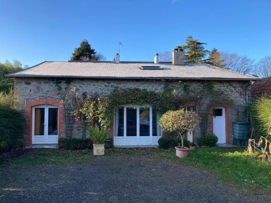 a brick house with ivy growing on it at La maisonnette de Naomi in Coutances