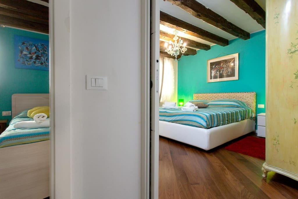 a bedroom with two beds in a room with green walls at San Marco Comfort in Venice