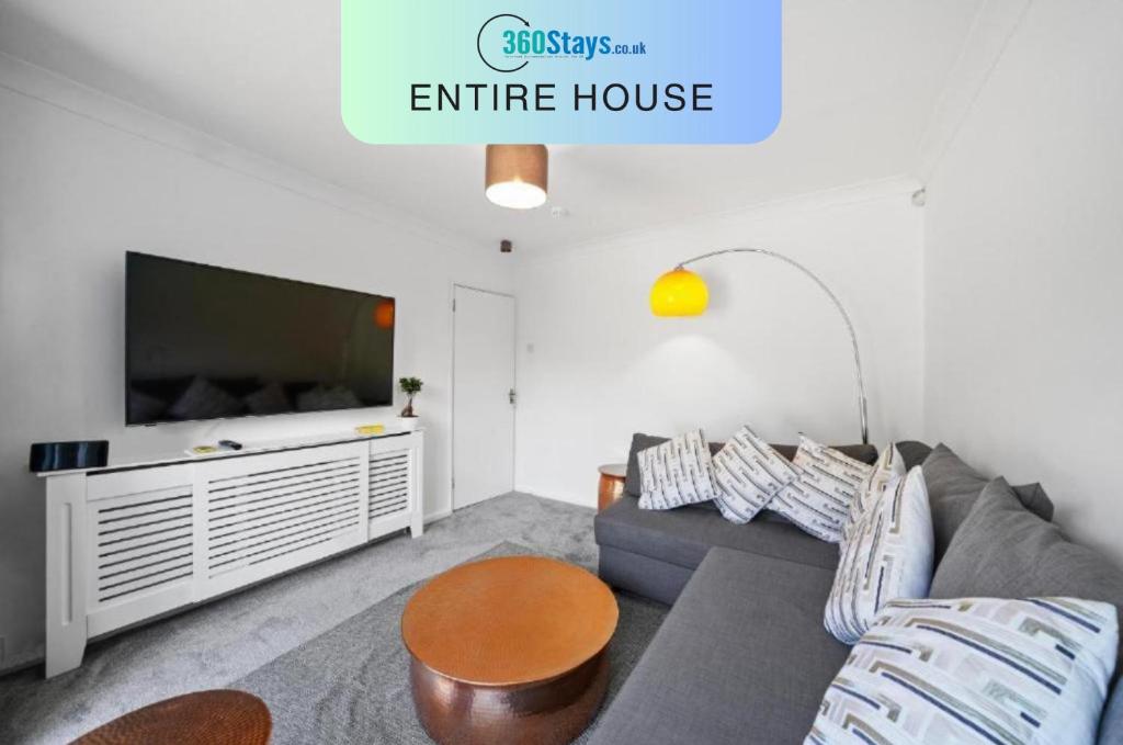 Il comprend un salon doté d'un canapé et d'une télévision à écran plat. dans l'établissement Hillary Serviced House with 5 Bedrooms up to 10 beds By 360Stays, à Slough