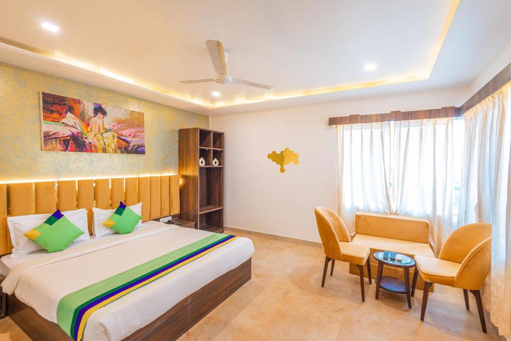 1 dormitorio con 1 cama, 1 sofá y 1 silla en Treebo Trend Salt Water Beach Resort, en Dapoli