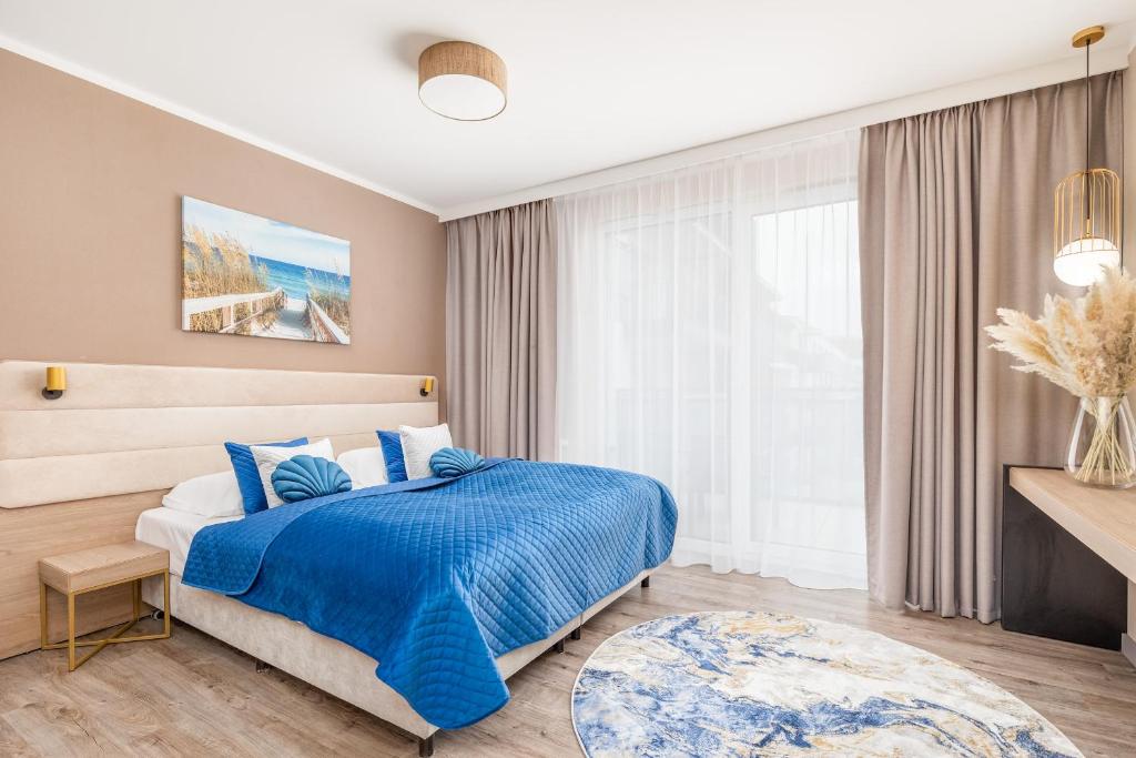 a bedroom with a blue bed and a window at Blue Seashell Studio Bel Mare near the Beach by Renters in Międzyzdroje