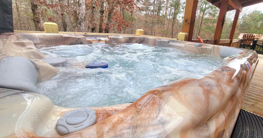 una gran bañera de hidromasaje en un patio trasero con agua en Relax & Unwind Hot-Tub 6 seater, Fire-Pit, Master King Bed, Near Wineries, Resort Amenities en Ellijay