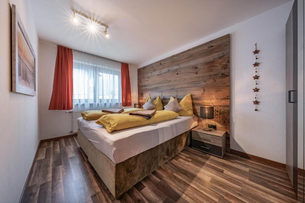 um quarto com uma cama grande e uma parede de madeira em Zillerstübchen em Schlitters