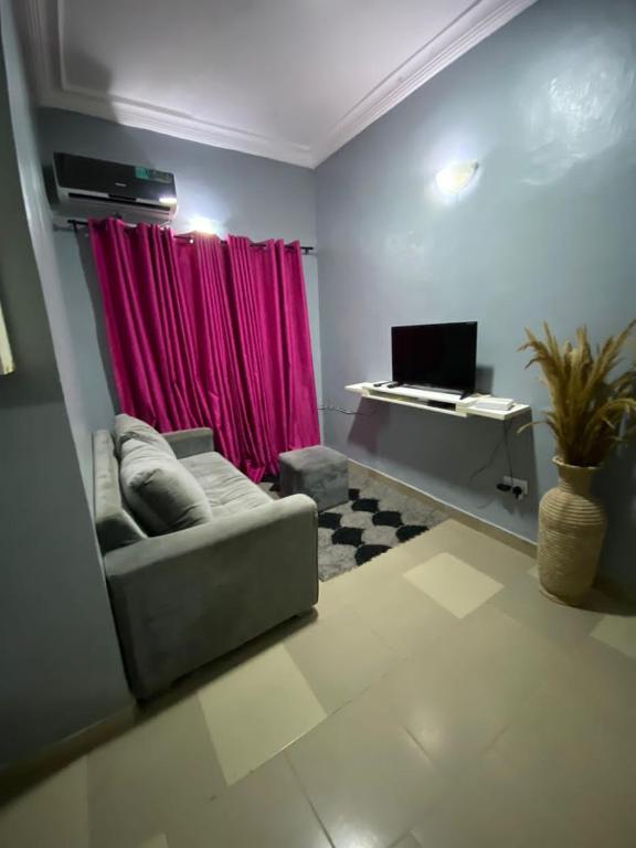 ein Wohnzimmer mit einem Sofa und einer Tastatur in der Unterkunft MJ Apartments in Lekki