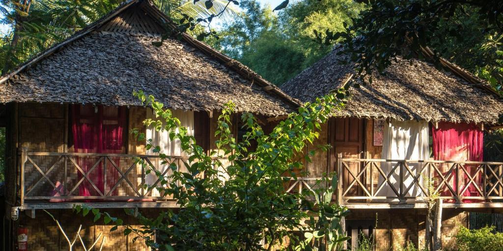 ein altes Haus mit Strohdach und Fenstern in der Unterkunft Sang Tong Huts in Mae Hong Son