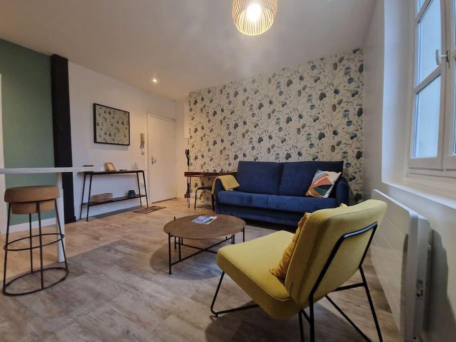 un salon avec un canapé bleu et une table dans l'établissement Le Foch, à Angers