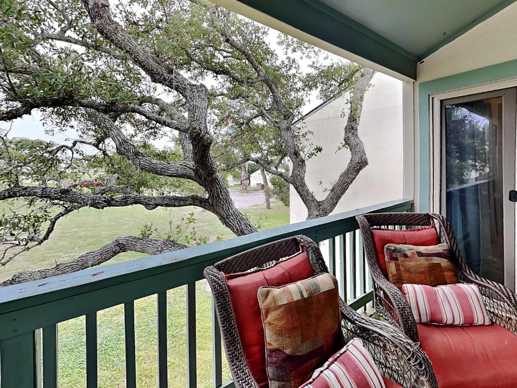 twee stoelen op een veranda met uitzicht op een boom bij A Bay From It All in Rockport