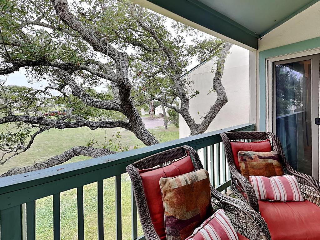 two chairs on a porch with a view of a tree at A Bay From It All in Rockport
