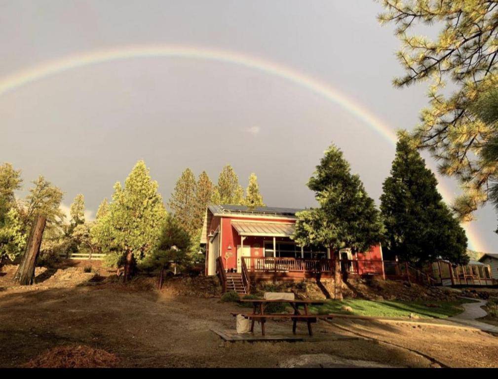 un arco iris sobre una casa con una mesa de picnic en Red Barn Retreat en North Fork