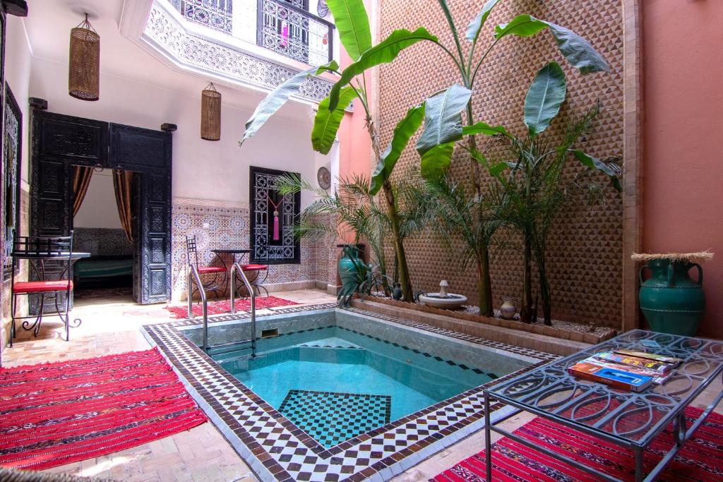 a swimming pool in a room with a house at Riad Hugo in Marrakesh