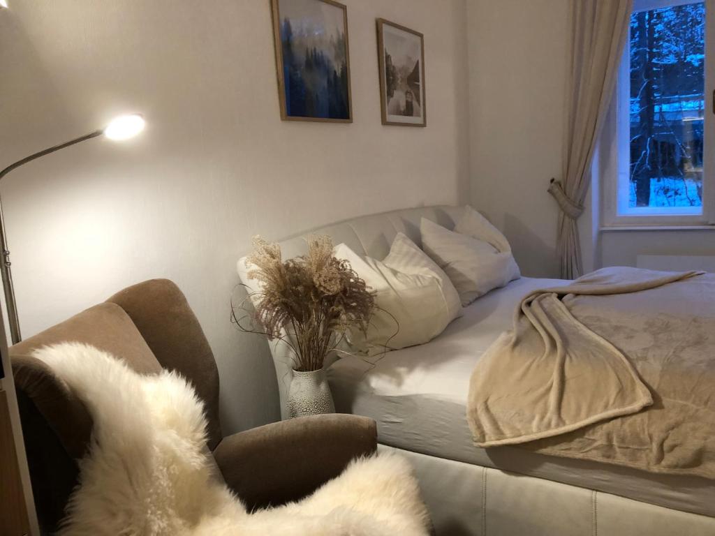 sala de estar con sofá y jarrón con flores en BRANDNEW - Executive Apartement 1 en Bad Gastein