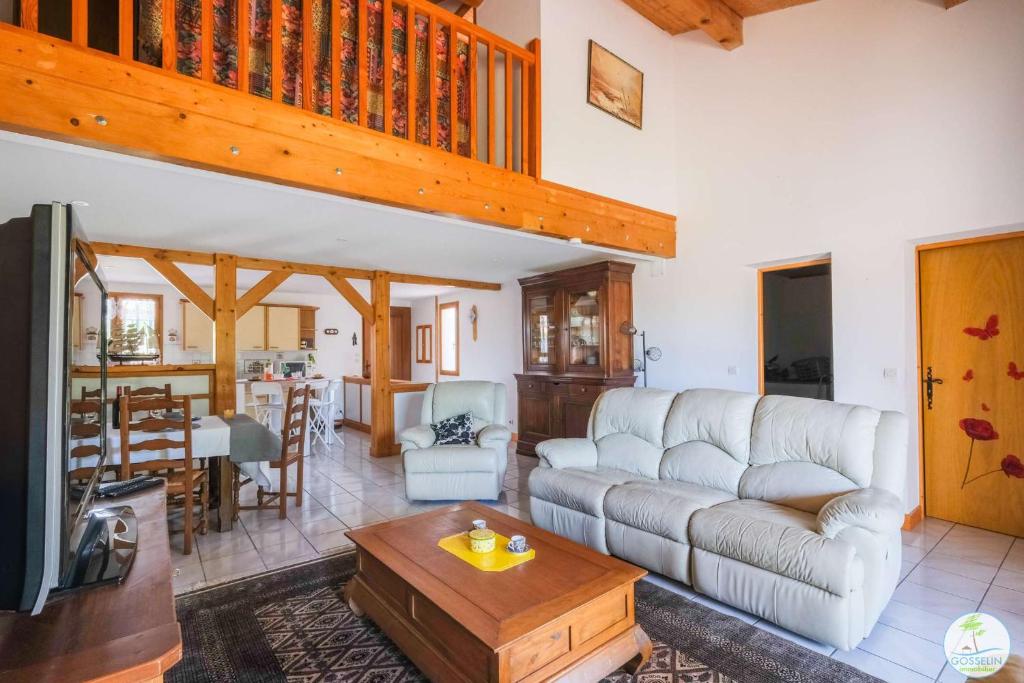 ein Wohnzimmer mit einem Sofa und einem Tisch in der Unterkunft Biscarrosse Bourg, Maison pour 6 personnes avec Terrasse et jardin in Biscarrosse