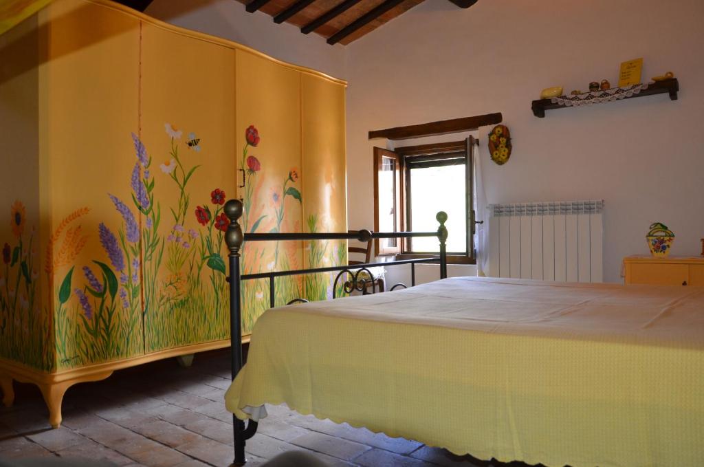 サン・セヴェリーノ・マルケにあるAgriturismo Villa Rosettaのベッドルーム1室(壁に絵画が描かれたベッド1台付)