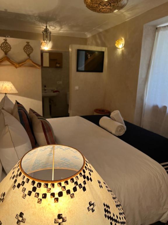 um quarto de hotel com uma cama e uma mesa em Riad Alena em Marraquexe