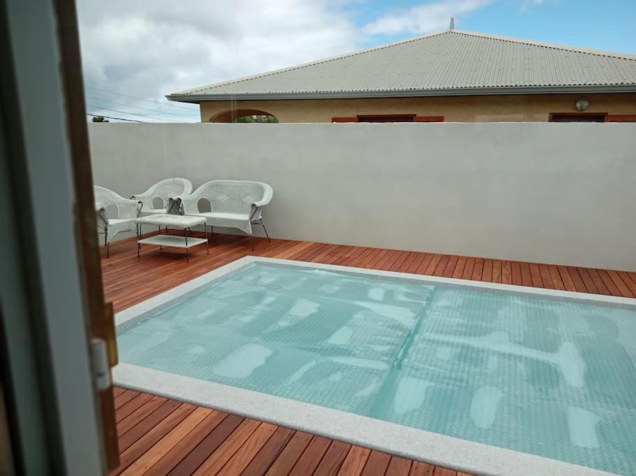 a large swimming pool on a wooden deck at Maison proche Chemin des Anglais in Saint-Denis