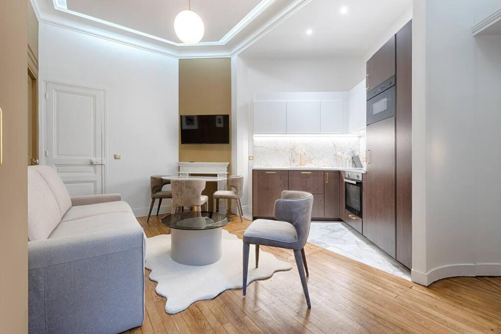 een woonkamer met een bank en een tafel bij MyKeypers Luxury Parisian Flat - Heart of Paris in Parijs