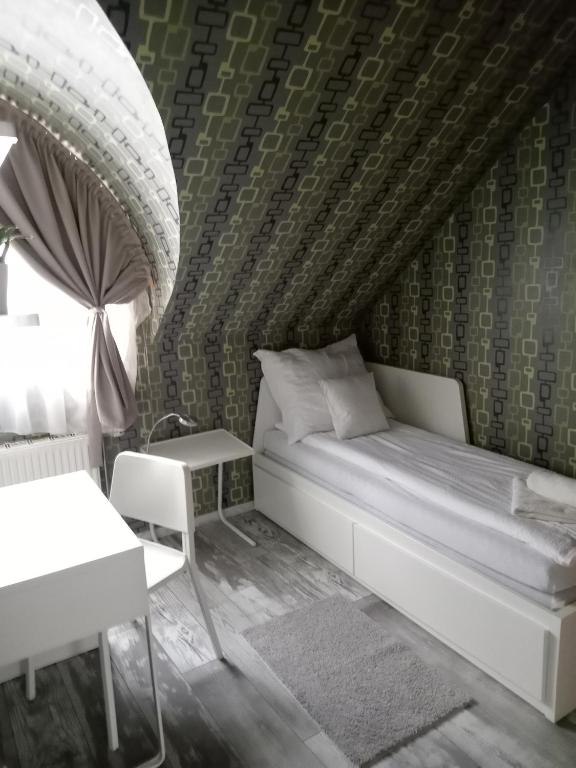 sypialnia z łóżkiem, krzesłem i stołem w obiekcie Ede Apartman w mieście Gyula